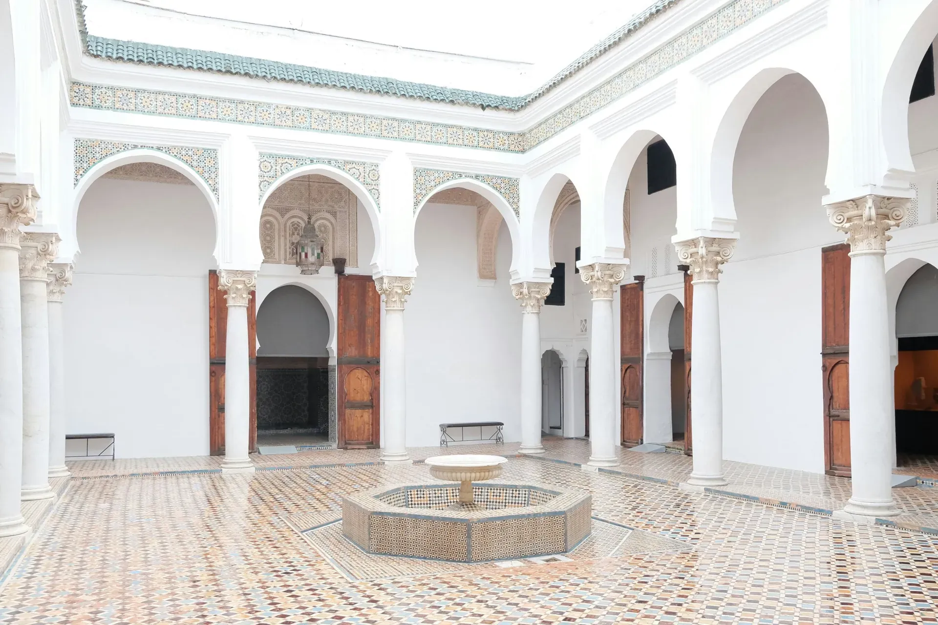 White arches and zellige tile floor in a Moroccan courtyard