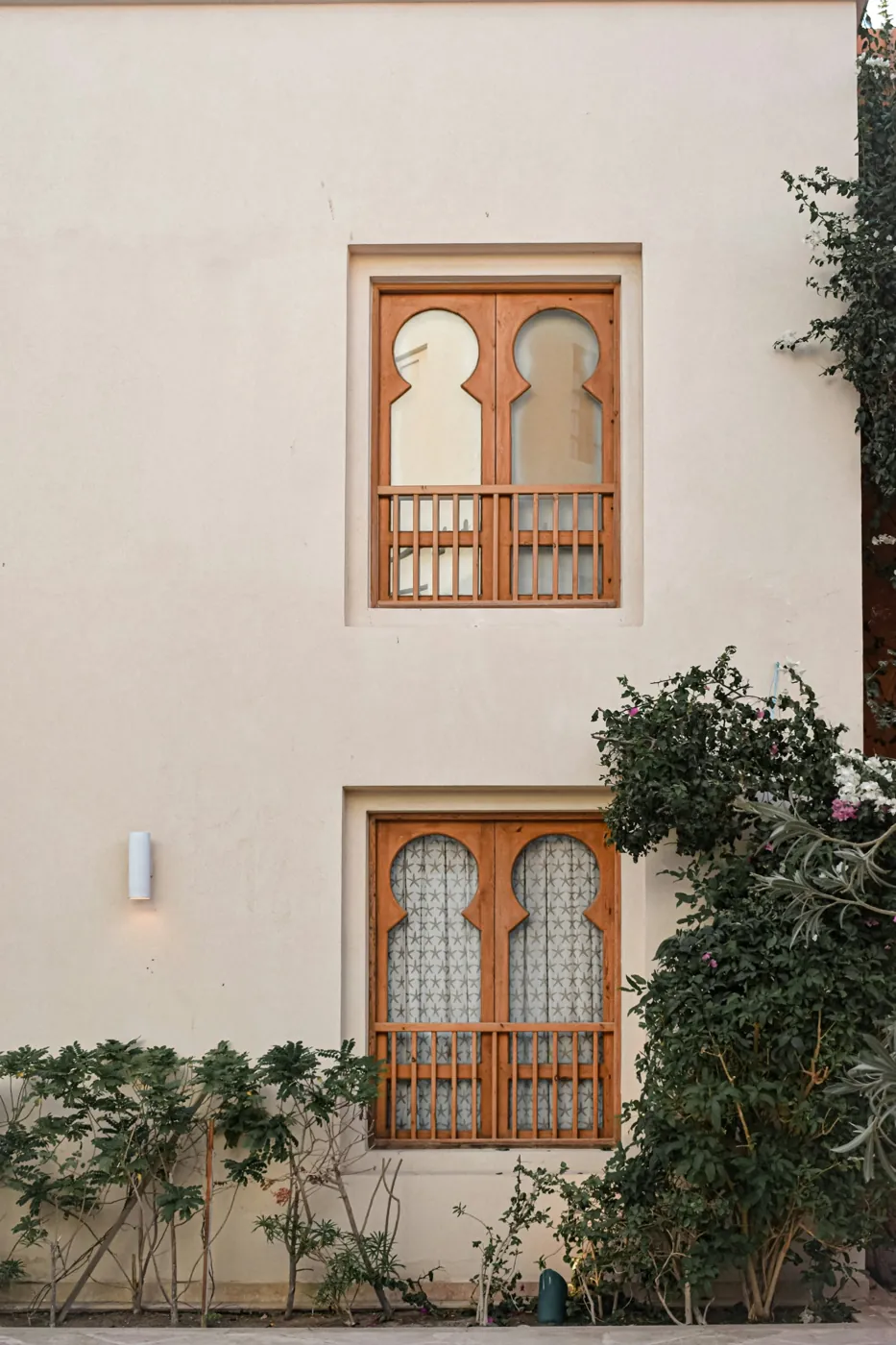 Cream-painted facade with carved wooden windows