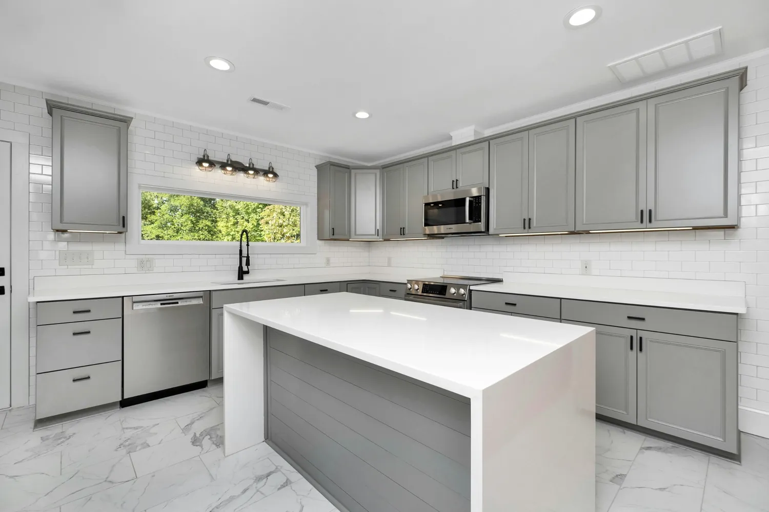 Modern kitchen with grey cabinets and a white island