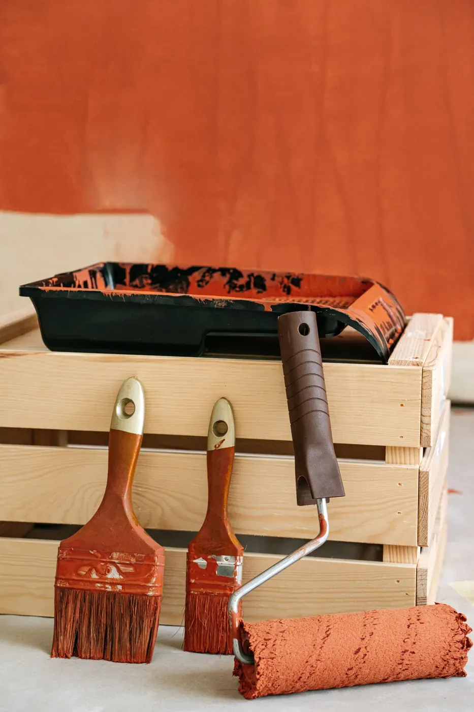 Brushes, roller and tray with terracotta paint