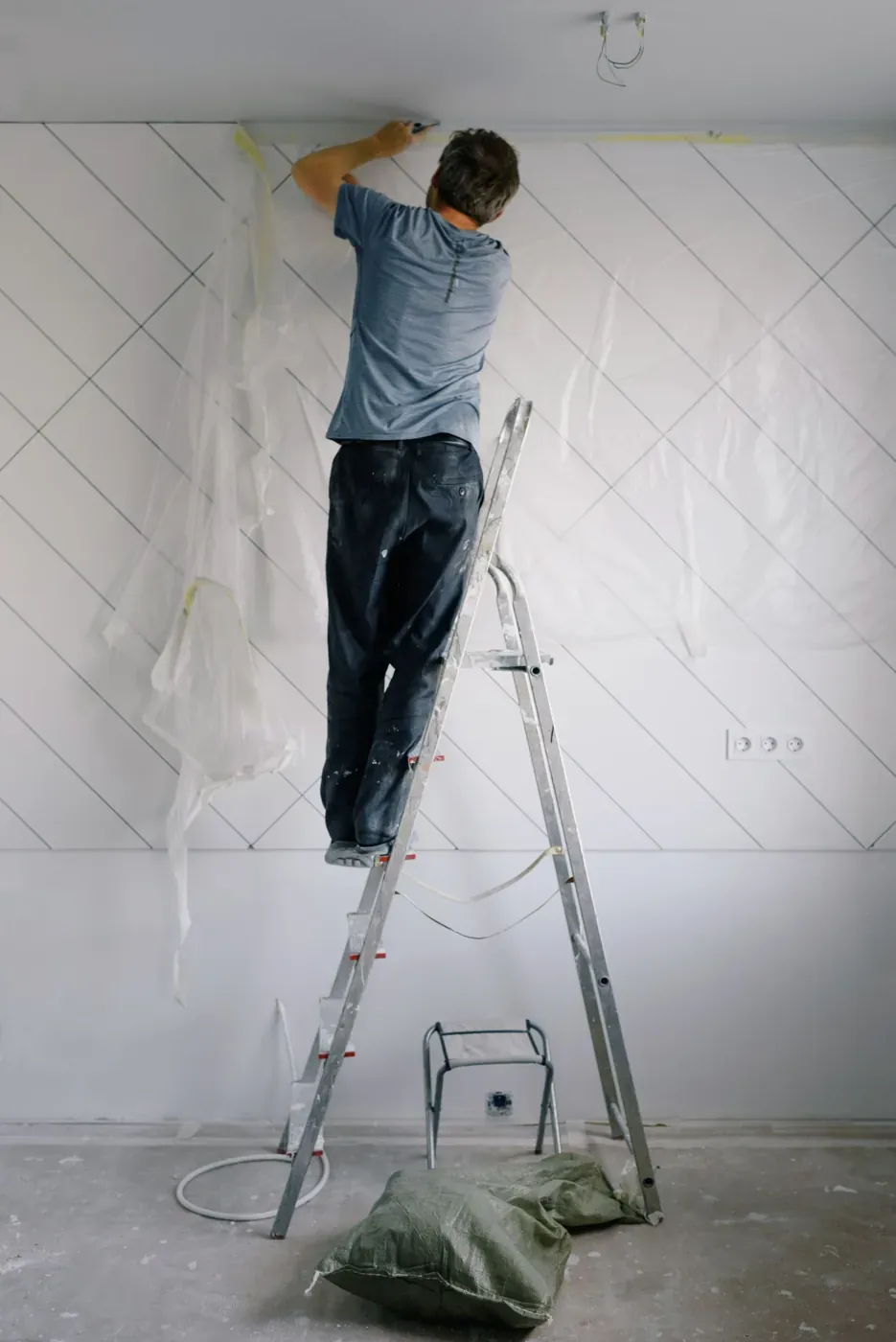 Worker masking and protecting a wall before work