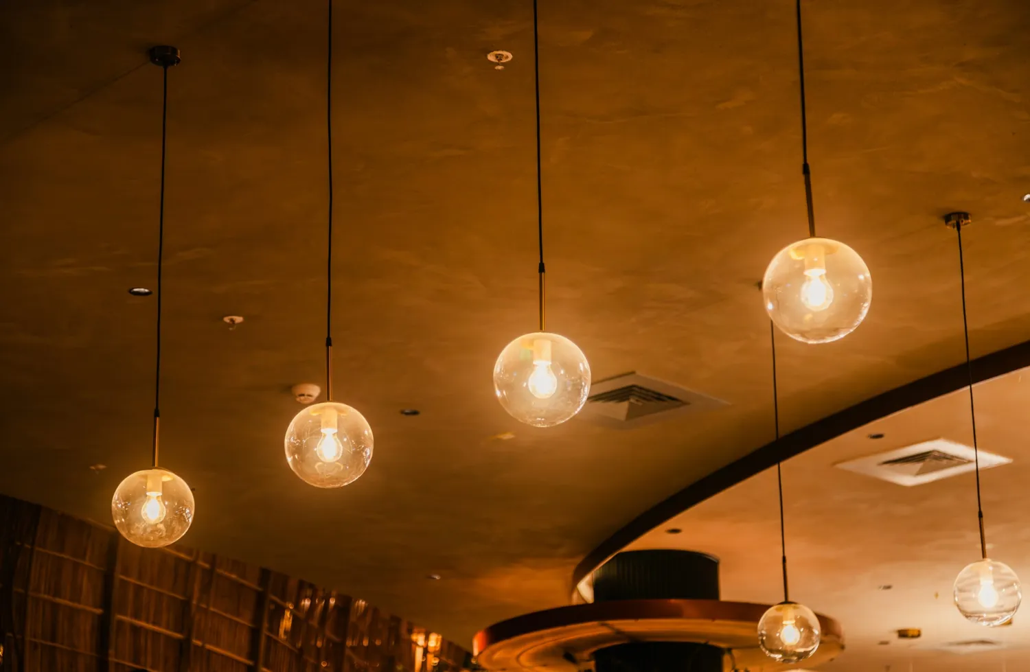Warm glass pendant lights hanging from a ceiling